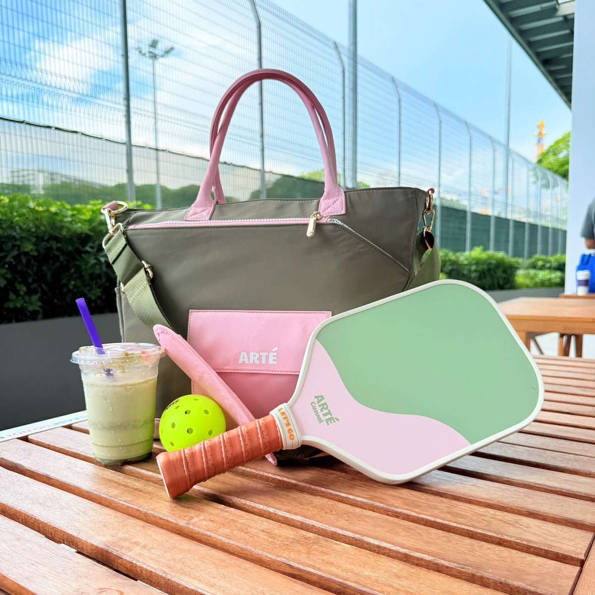 The Signature Bag lifestyle flat-lay with a pickleball paddle, ball, and drink on a court-side table