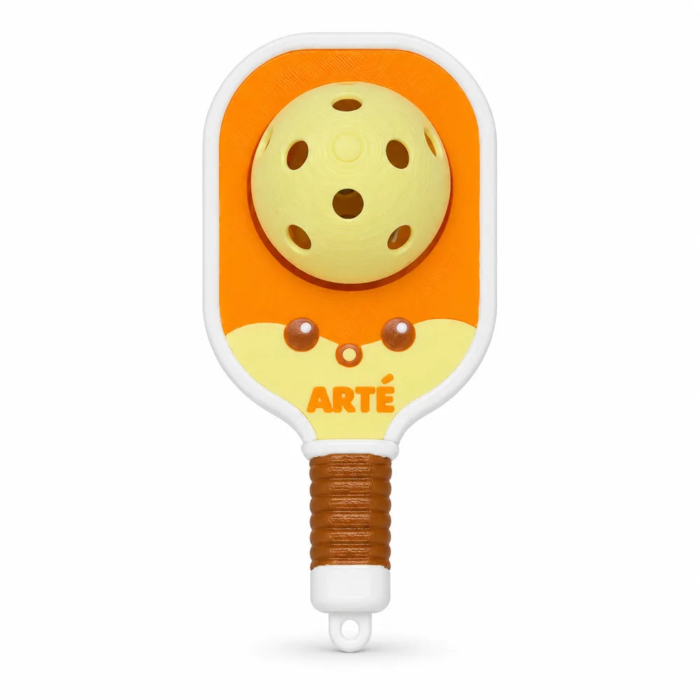 Dinky Clicker: an orange mini paddle charm with a yellow ball and a smiling face